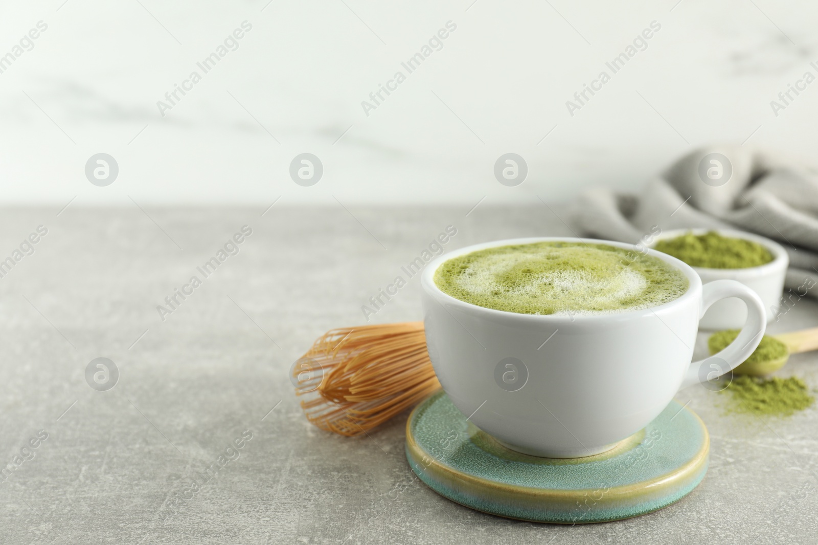 Photo of Cup of fresh matcha latte on light grey table. Space for text