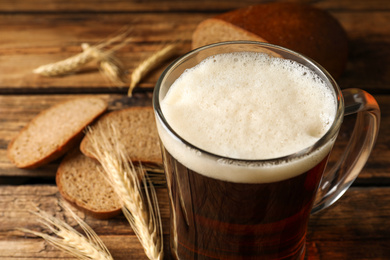 Mug of delicious kvass on wooden table, closeup