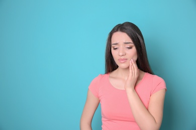 Photo of Woman with sensitive teeth on color background