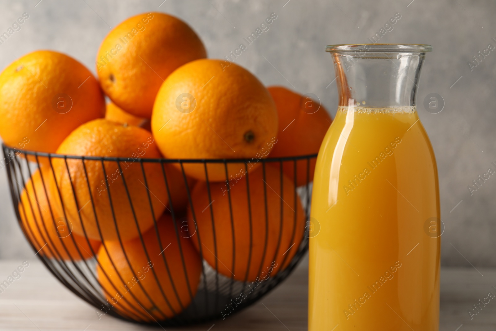 Photo of Tasty fresh oranges and juice in jug on table, closeup