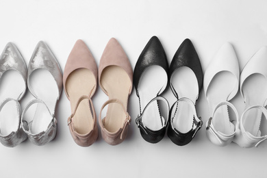 Photo of Many stylish female shoes on white background, top view