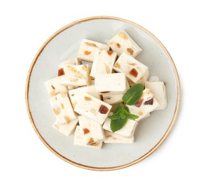 Photo of Plate with pieces of delicious nougat and mint isolated on white, top view