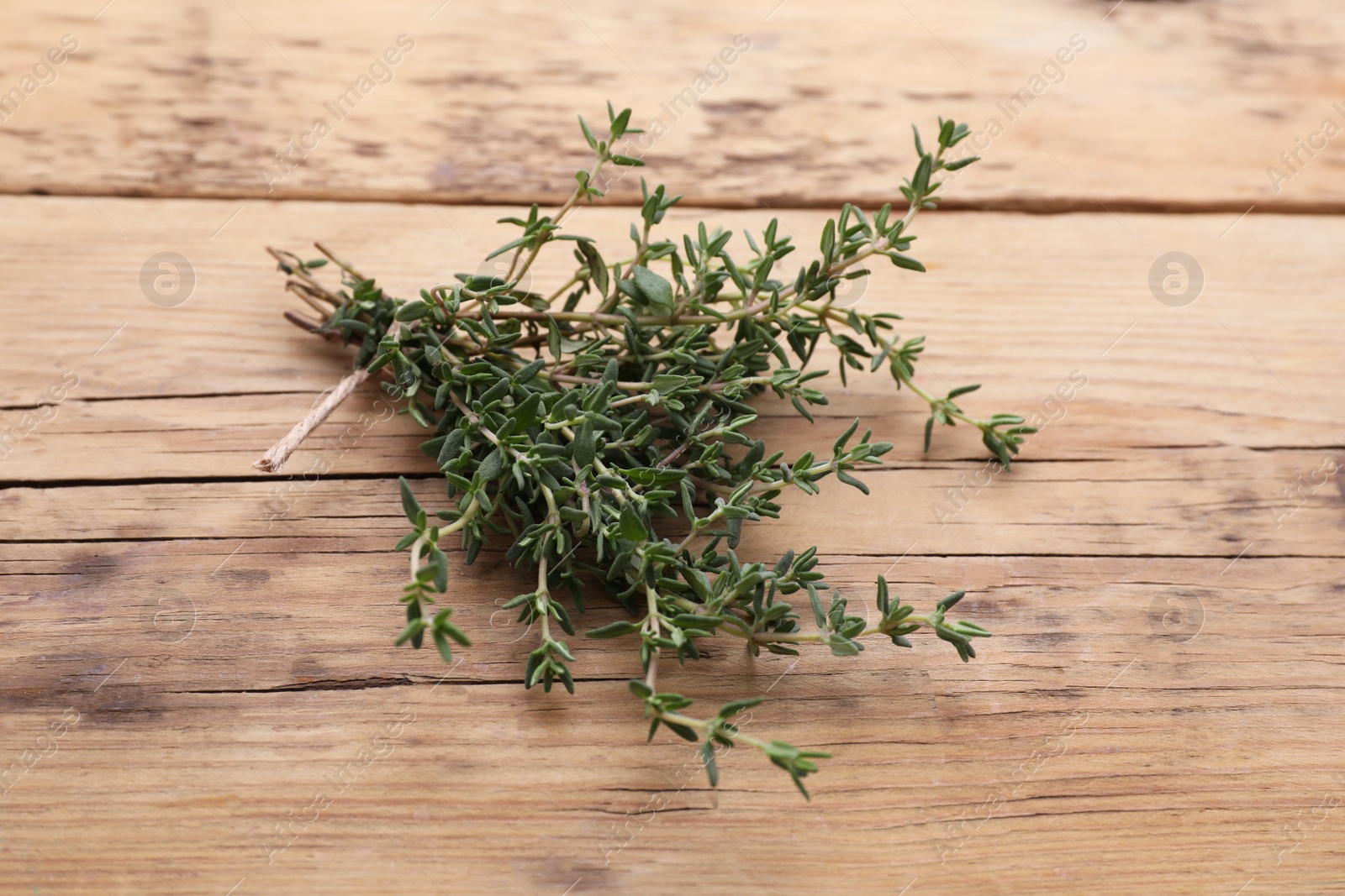 Photo of Bunch of fresh thyme on wooden table