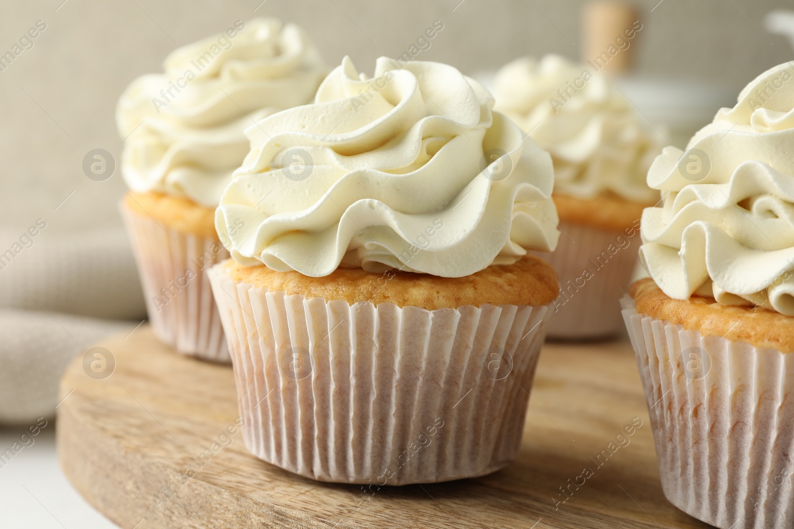 Photo of Tasty vanilla cupcakes with cream on table, closeup