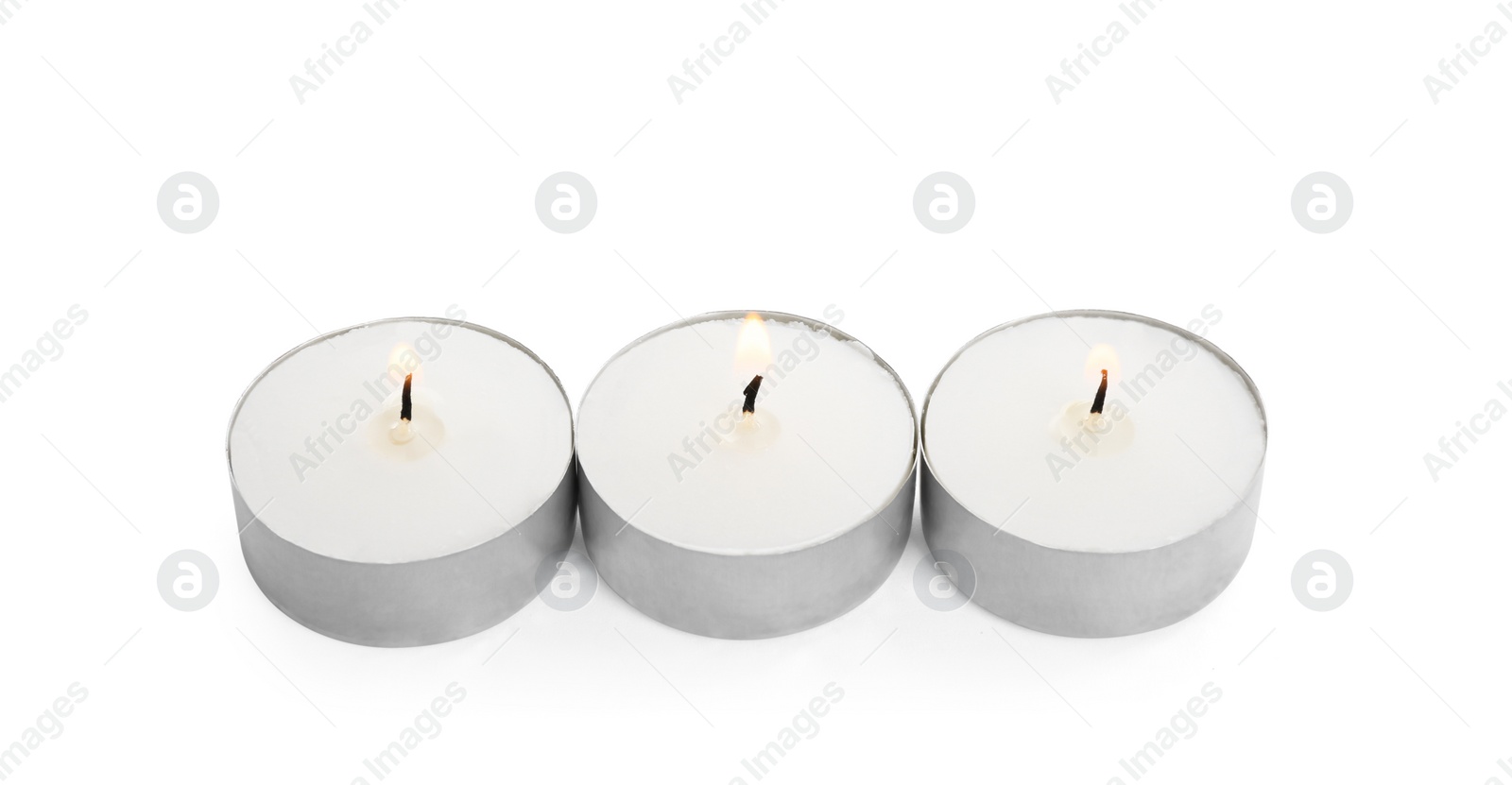 Photo of Wax candles burning on white background. Interior elements