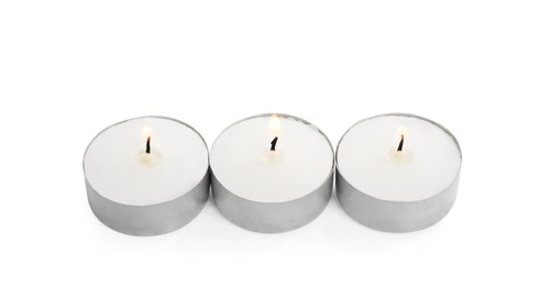 Wax candles burning on white background. Interior elements