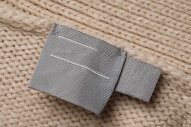 Photo of Clothing label on beige garment, top view