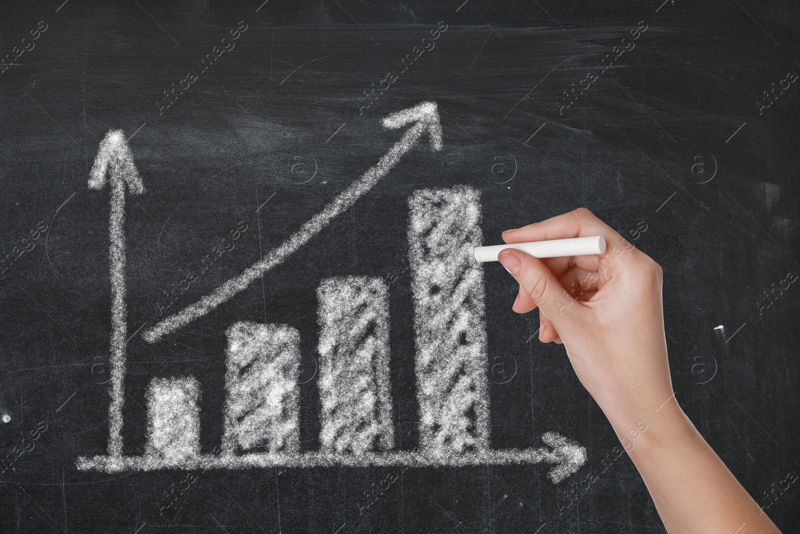 Image of Woman drawing bar chart on black chalkboard, closeup