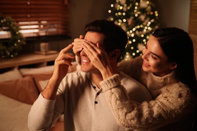 Photo of Happy couple in festively decorated room. Christmas celebration