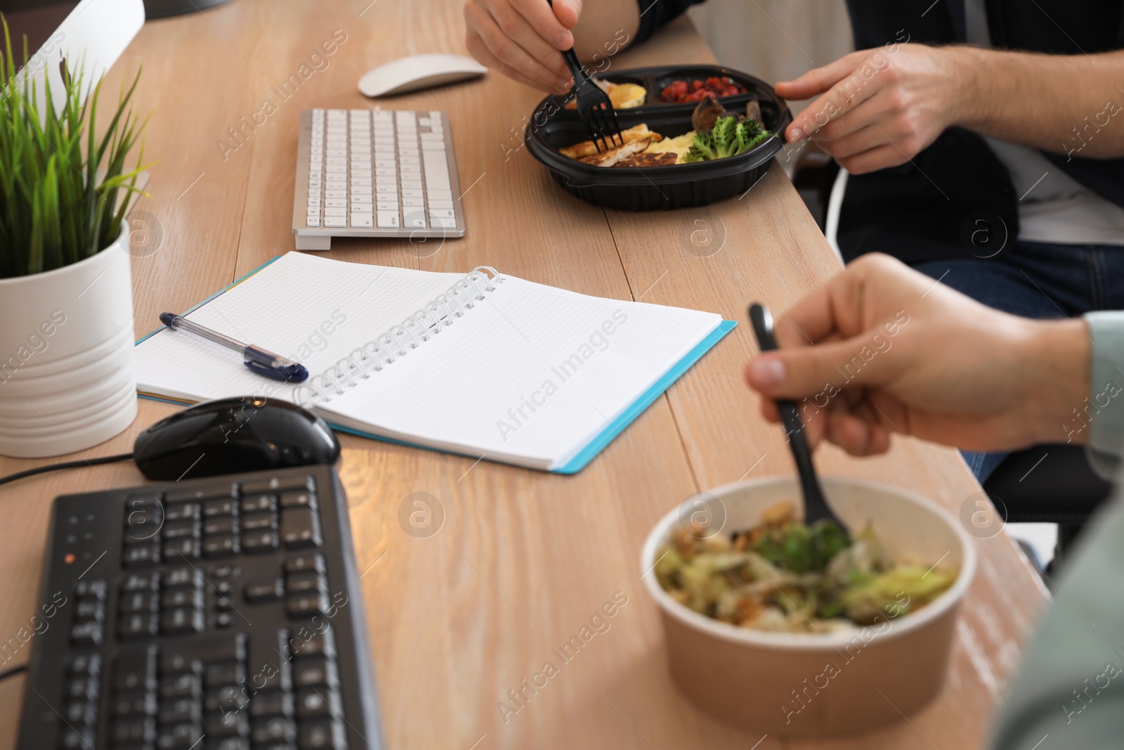 Photo of Office employees having lunch at workplace, closeup. Food delivery