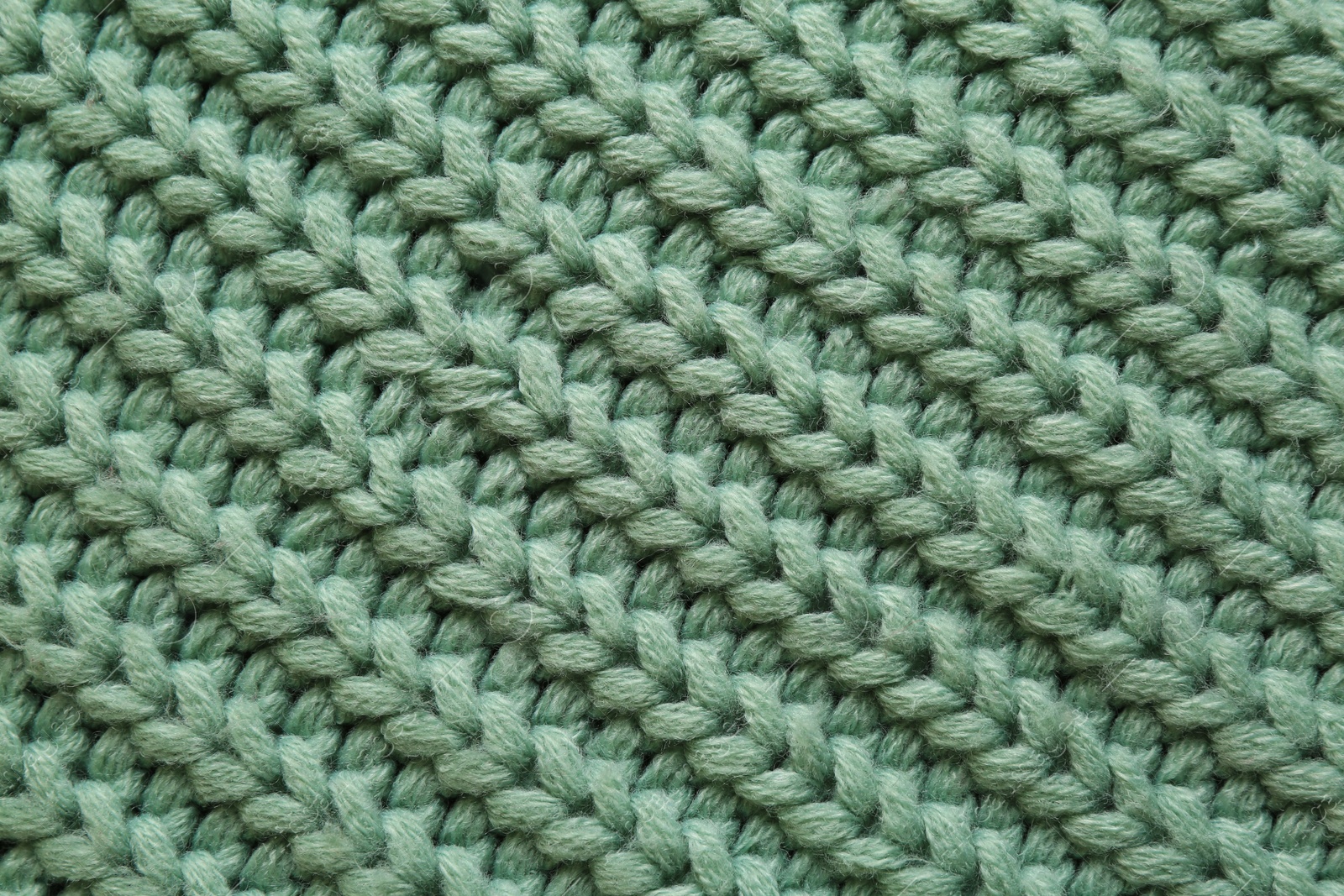 Photo of Beautiful pale green knitted fabric as background, top view