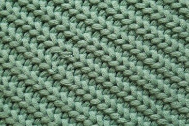 Photo of Beautiful pale green knitted fabric as background, top view