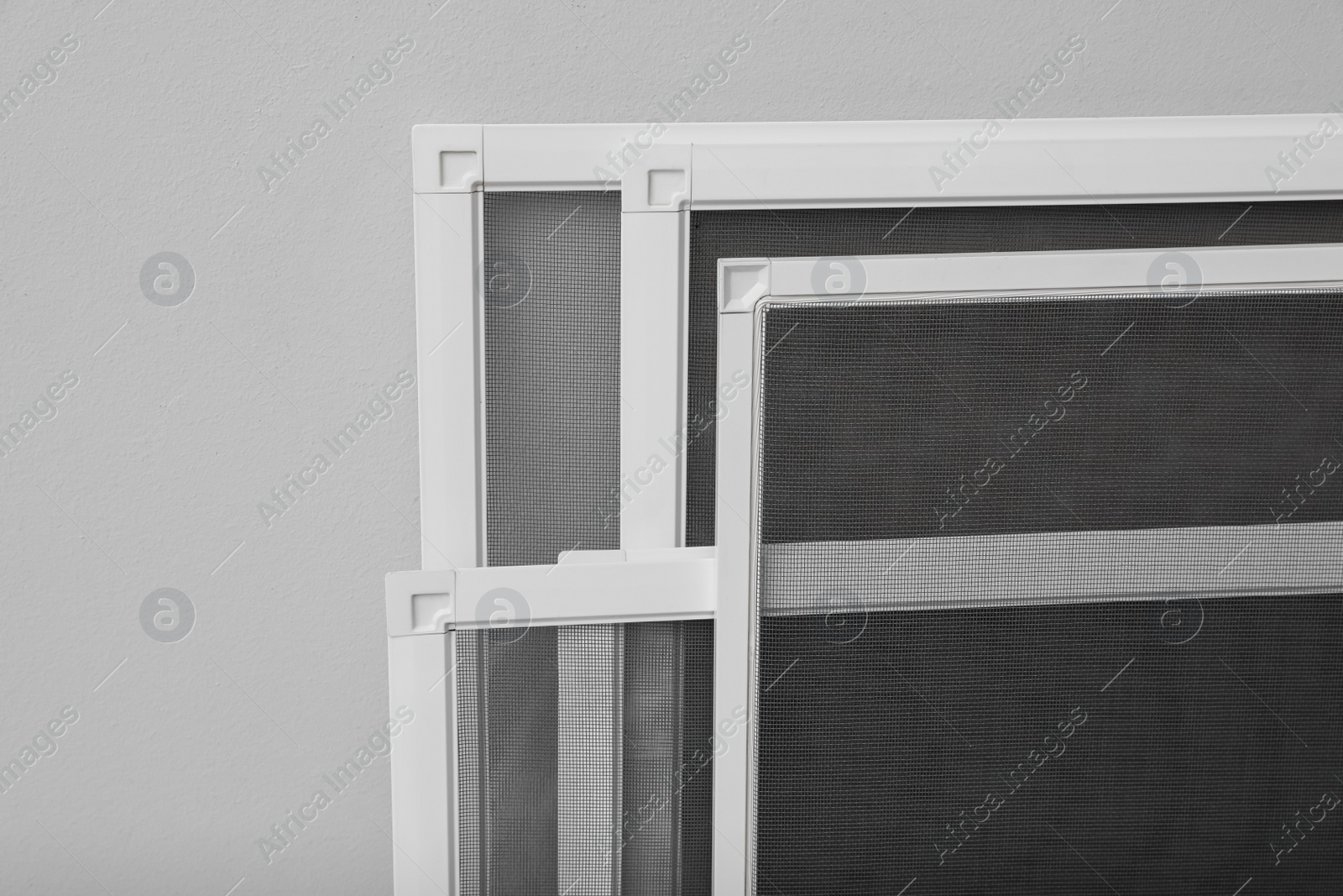 Photo of Set of window screens on light grey background, closeup