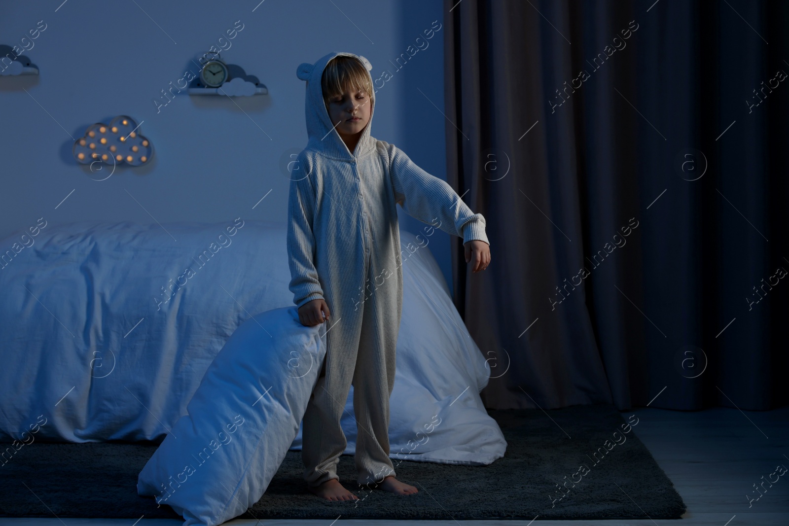 Photo of Boy in pajamas sleepwalking indoors at night