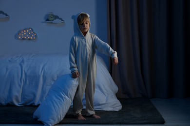 Photo of Boy in pajamas sleepwalking indoors at night