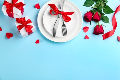 Photo of Beautiful table setting on light blue background, above view with space for text. Valentine's Day dinner