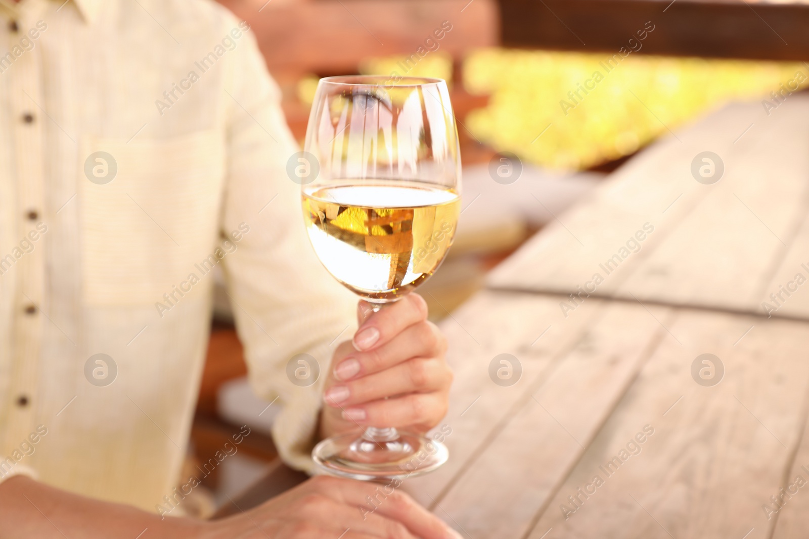 Photo of Woman with glass of white wine in outdoor cafe, closeup