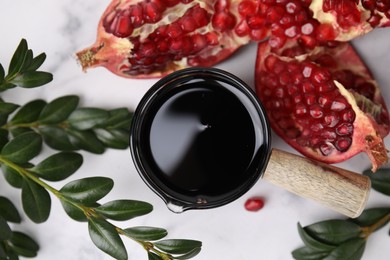 Photo of Tasty pomegranate sauce, fruits and branches on white table, flat lay