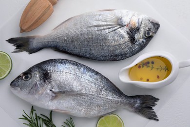 Photo of Fresh dorado fish and ingredients on white table, flat lay