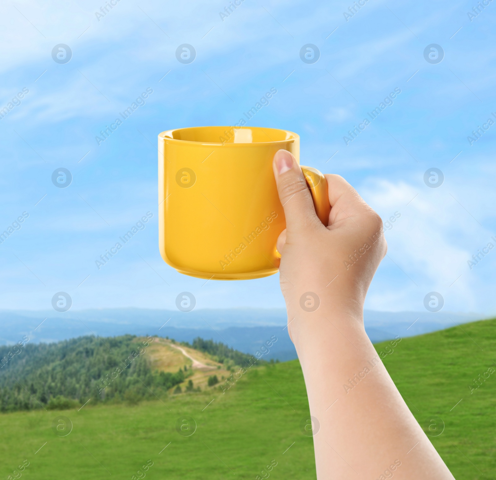 Image of Closeness to nature. Woman holding cup in mountains, closeup