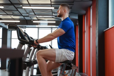 Man training on exercise bike in gym
