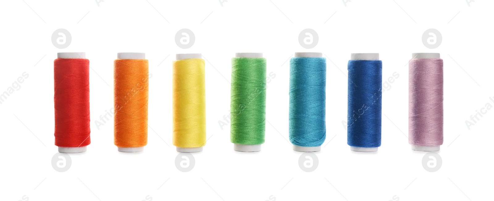 Photo of Set of colorful sewing threads on white background