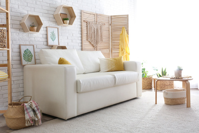 Photo of Comfortable white sofa in modern room. Interior design