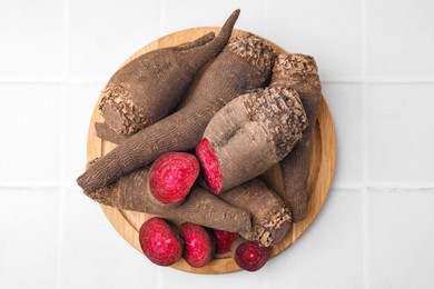 Whole and cut red beets on white table, top view