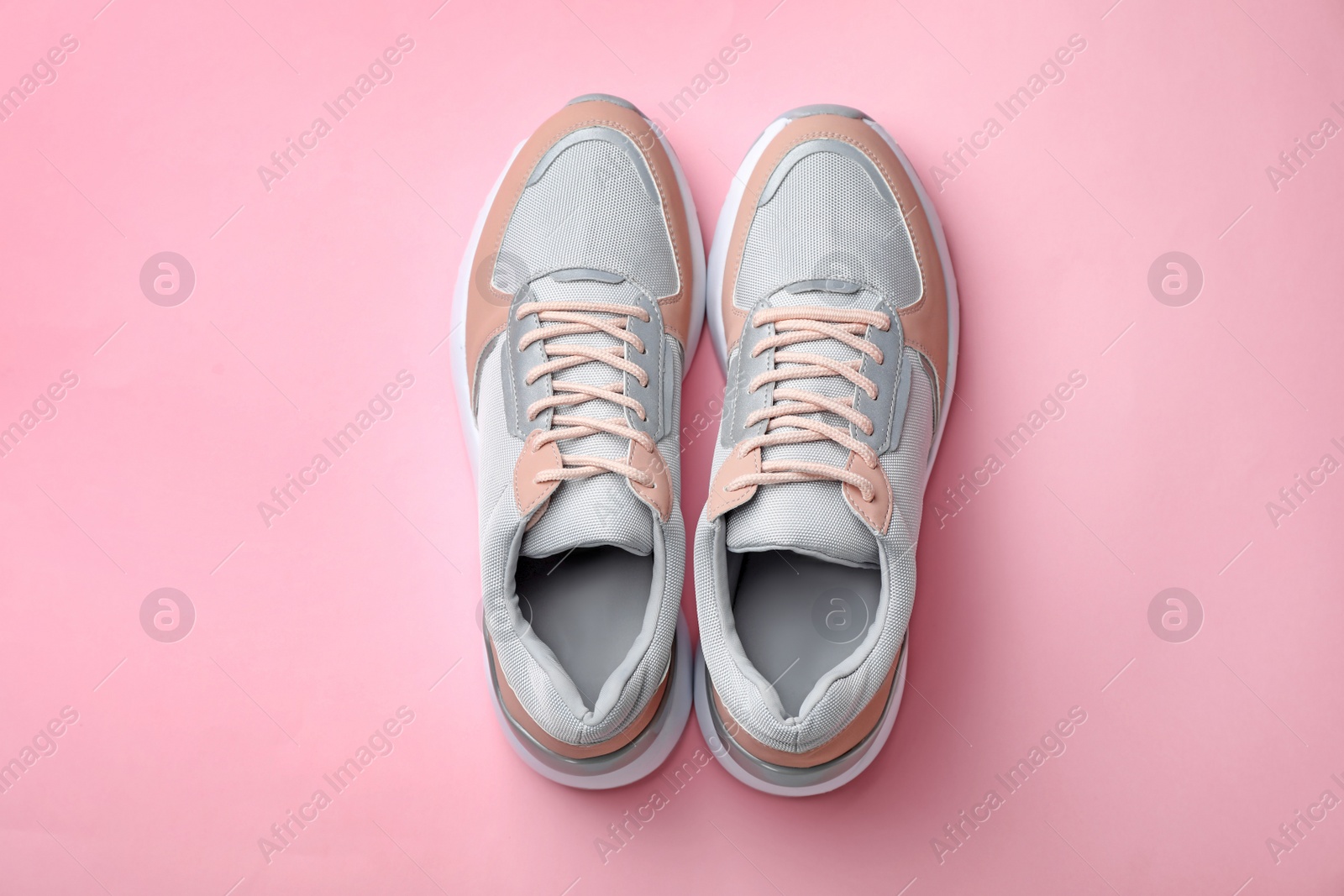 Photo of Pair of stylish sneakers on color background, top view