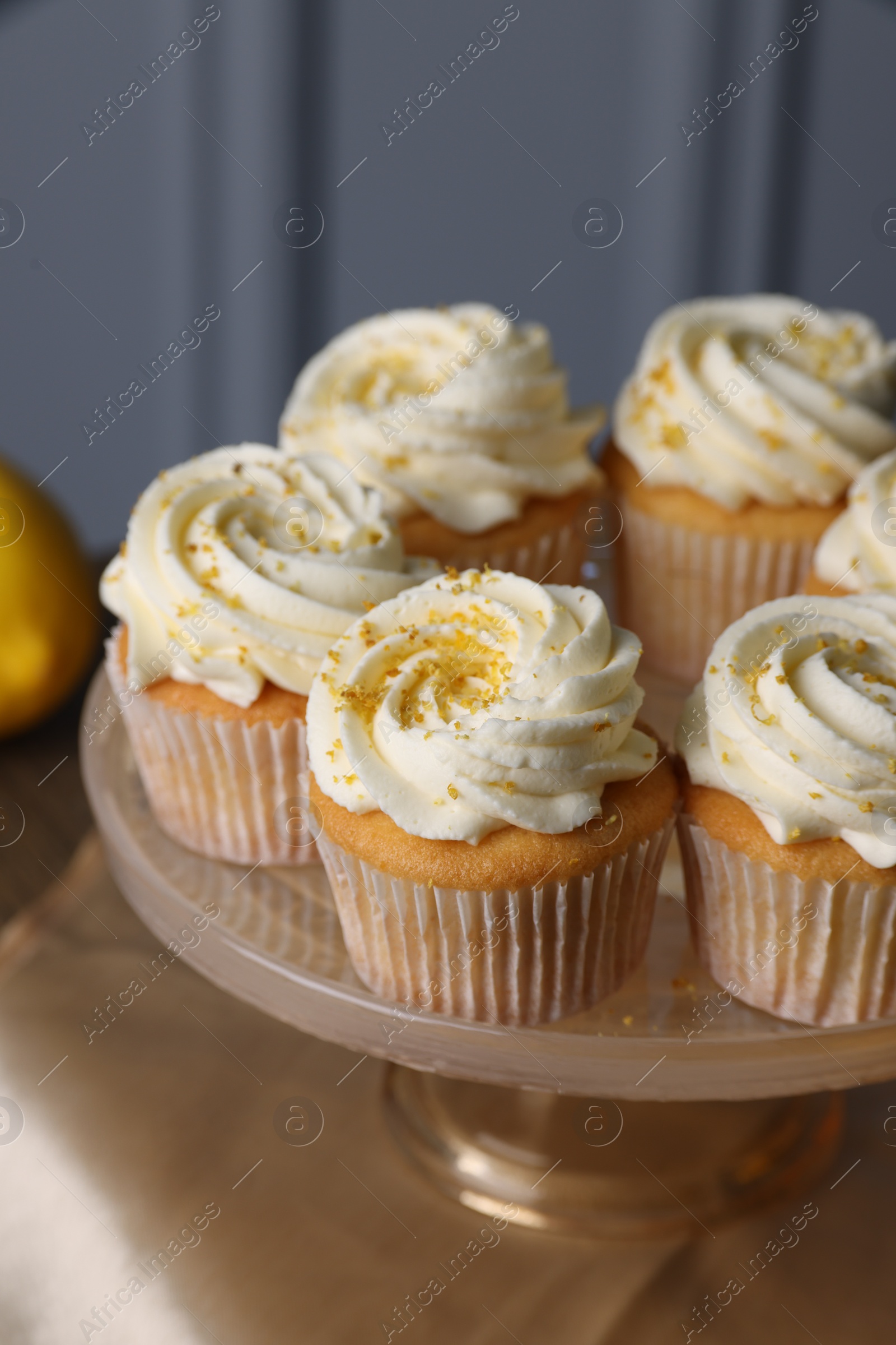 Photo of Delicious lemon cupcakes with white cream on table, closeup