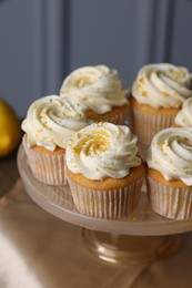 Delicious lemon cupcakes with white cream on table, closeup