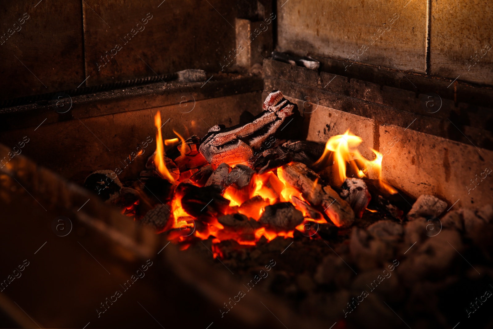 Photo of Oven with burning firewood in restaurant kitchen, closeup view