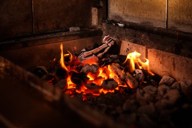 Oven with burning firewood in restaurant kitchen, closeup view