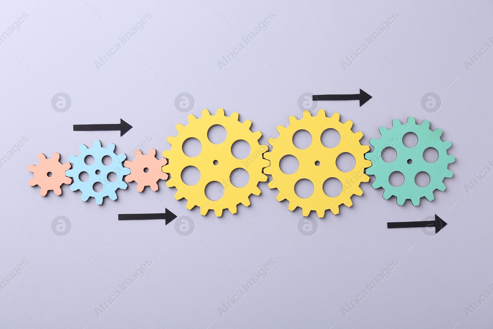 Photo of Business process organization and optimization. Scheme with wooden figures and arrows on lilac background, top view