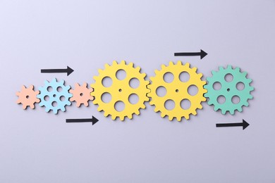 Business process organization and optimization. Scheme with wooden figures and arrows on lilac background, top view