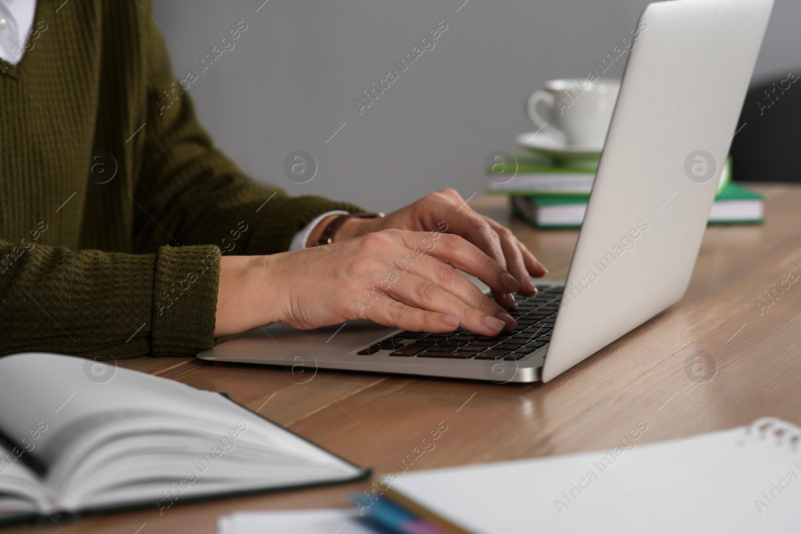 Photo of Woman with modern laptop learning at table indoors, closeup