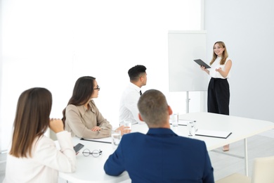 Photo of Female business coach talking to audience in office
