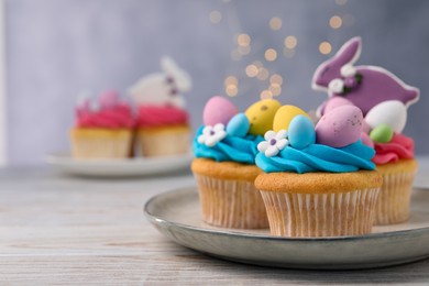 Photo of Tasty decorated Easter cupcakes on wooden table, space for text