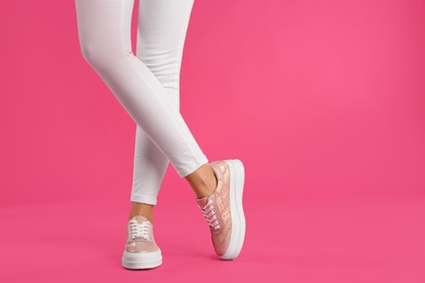 Woman wearing shoes on pink background, closeup. Space for text