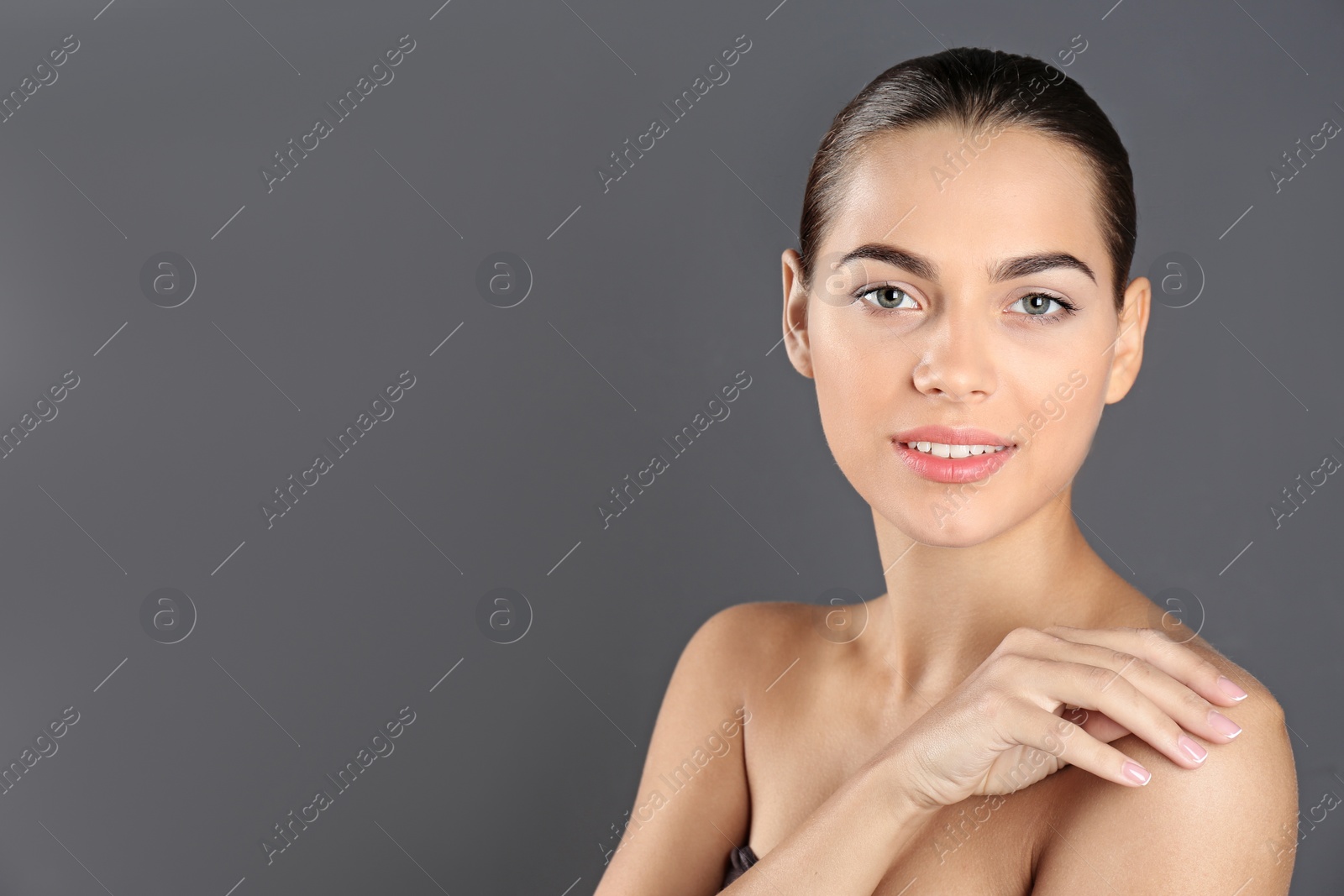 Photo of Portrait of beautiful young woman and space for text on grey background. Cosmetic surgery concept