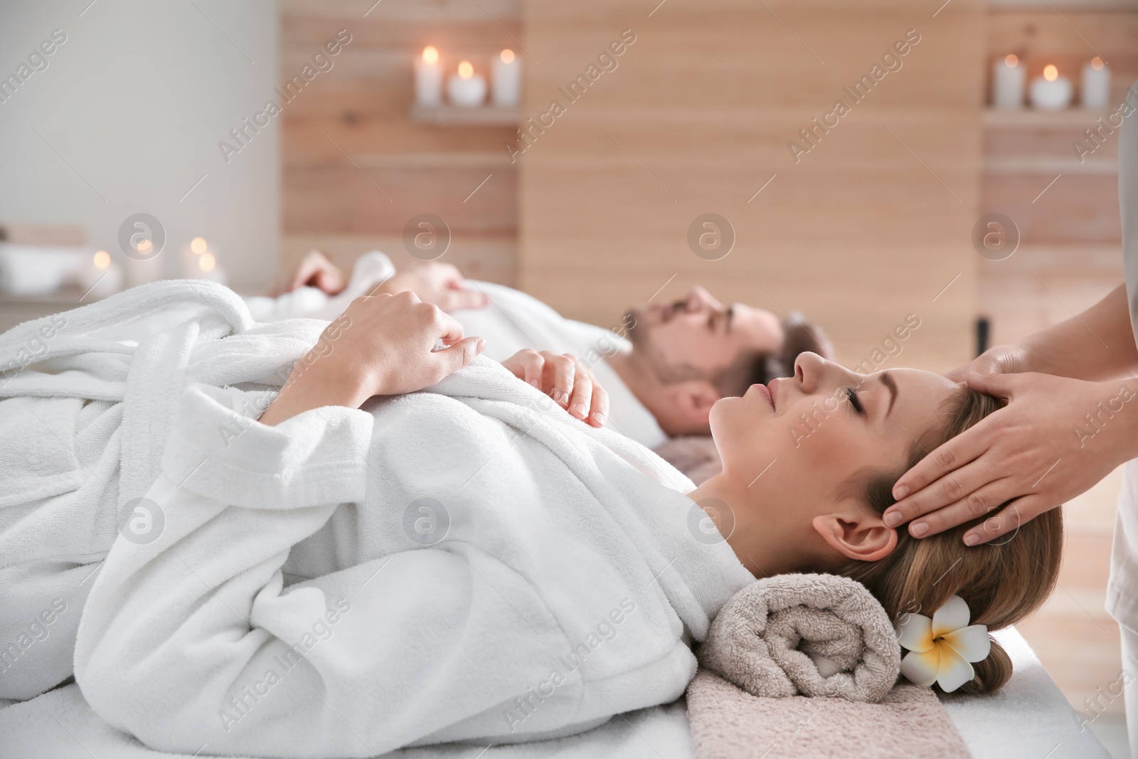 Photo of Young woman enjoying head massage in spa salon