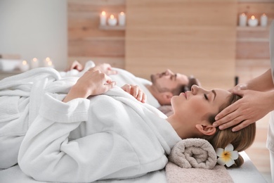 Young woman enjoying head massage in spa salon