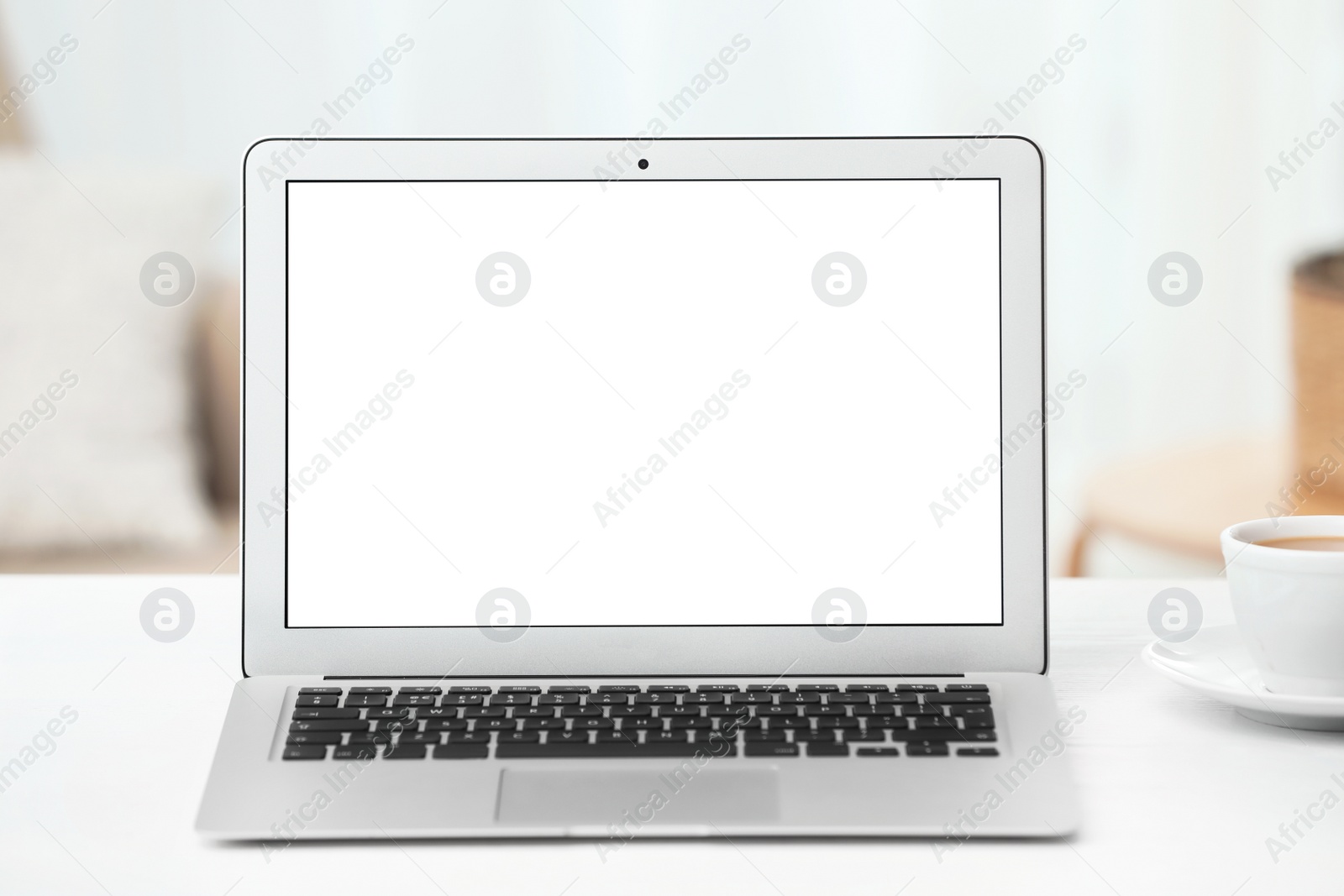 Photo of Laptop with blank screen on table indoors. Space for text