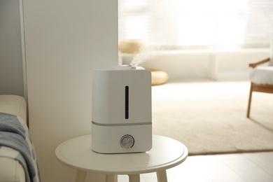 Photo of Modern humidifier on table indoors. Space for text