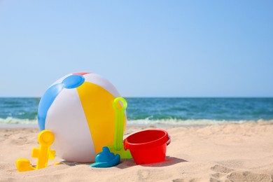 Photo of Many different sand toys and beach ball near sea, space for text