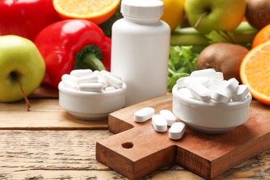 Photo of Dietary supplements. Plastic bottle, pills in bowls and food products on wooden table