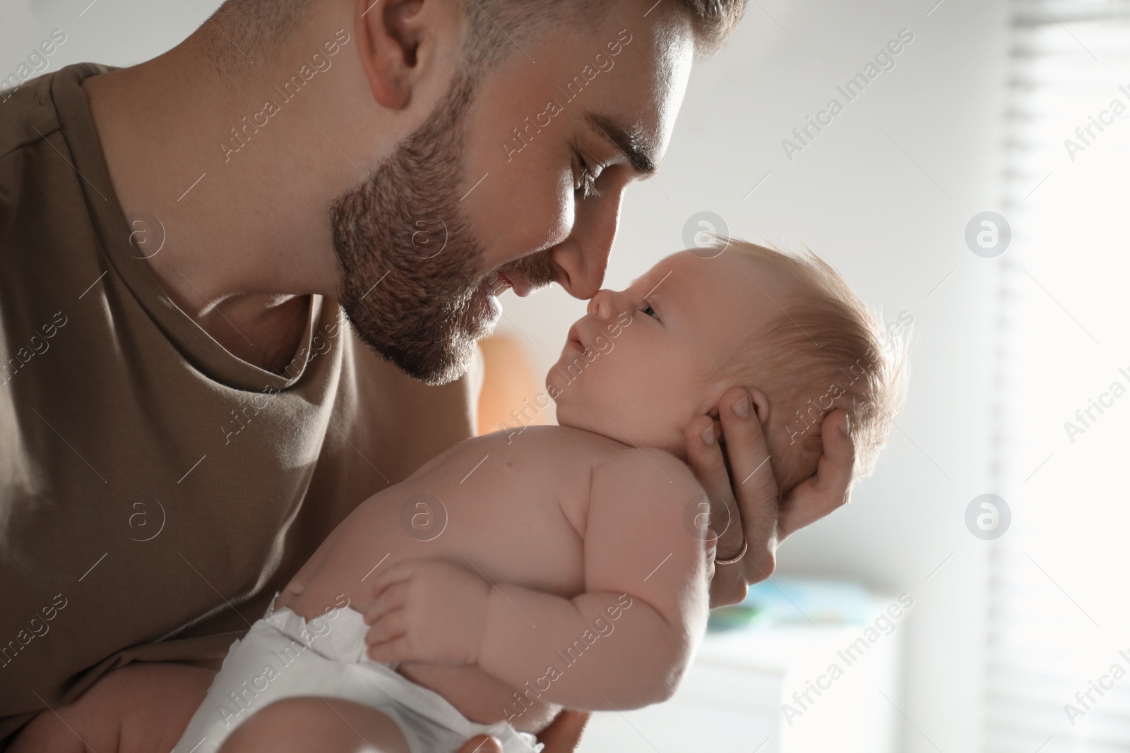 Photo of Father with his newborn son at home, closeup