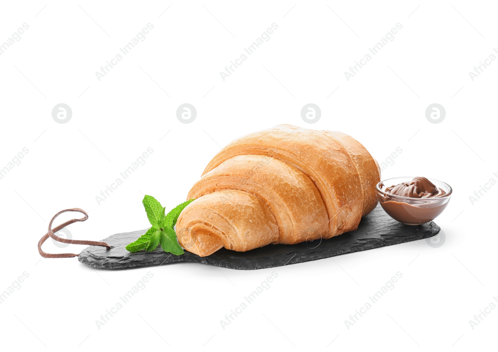 Photo of Slate plate with tasty croissant and chocolate sauce on white background