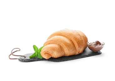 Photo of Slate plate with tasty croissant and chocolate sauce on white background