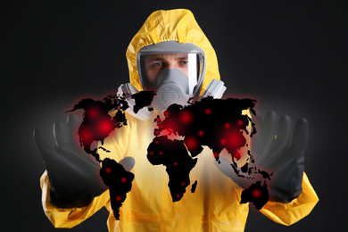Man in chemical protective suit and world map on black background. Virus spread